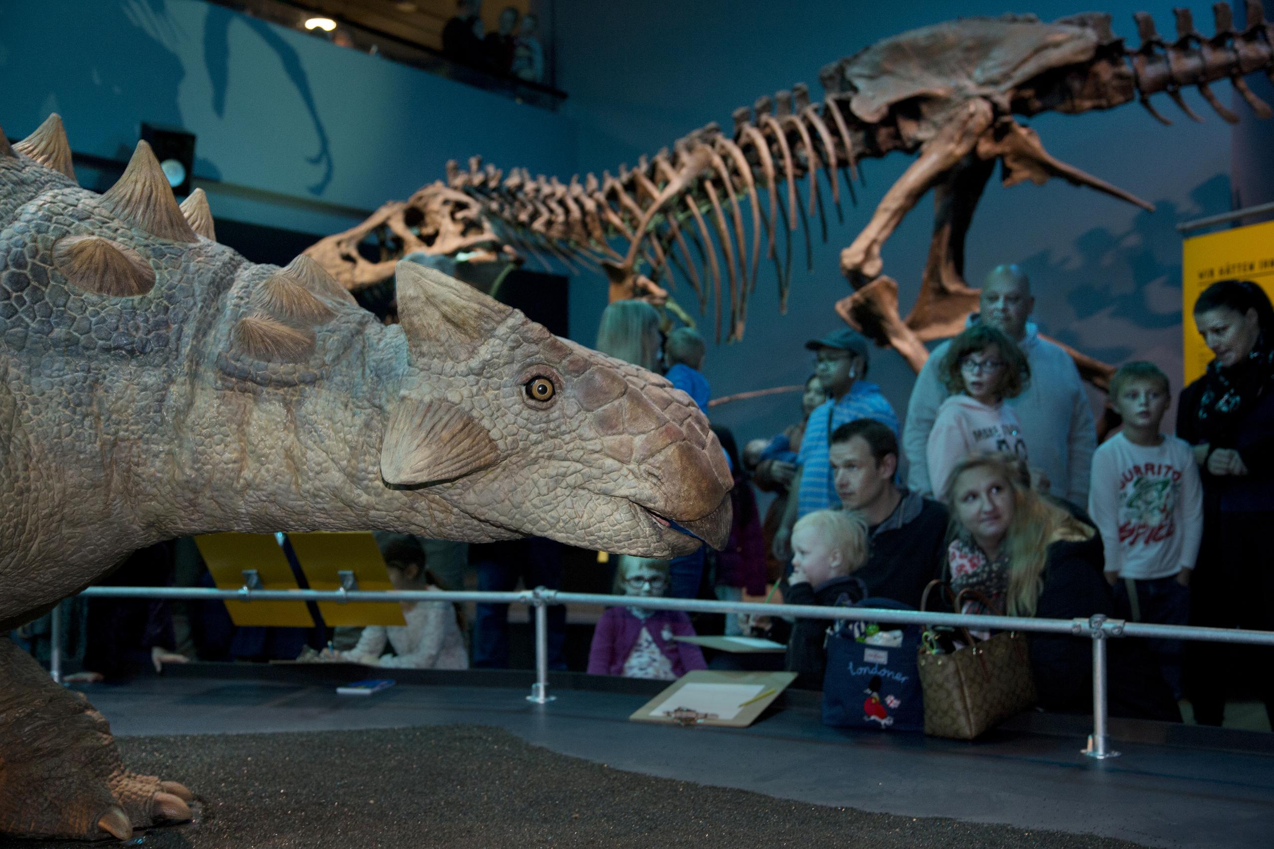 Dinosaurier mit Menschen im Hintergrund